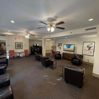 A cozy lounge area with comfortable seating, a flat-screen TV, and decorative posters on the walls.