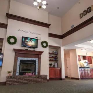 A spacious lobby with a fireplace, television, and festive decorations.