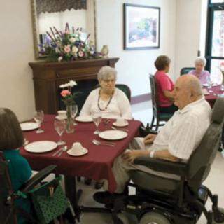 A group of seniors dining together in a community setting.