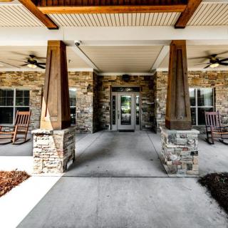 A welcoming front porch with stone pillars and rocking chairs.