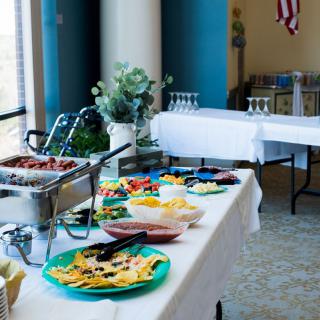 A buffet table set up for an event, featuring a variety of dishes and glassware.