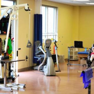 A physical therapy clinic with various rehabilitation equipment and exercise machines.