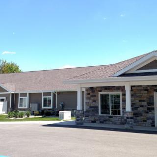 A modern, single-story residential building with a garage and driveway.