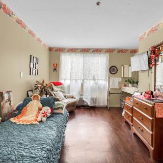 A cozy bedroom with a bed, dresser, and various decorations.