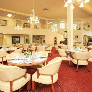 An elegant dining area with upholstered chairs and chandeliers.