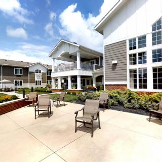 A sunny outdoor patio area with chairs and surrounding buildings.