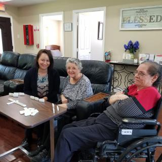 A group of people sitting together indoors, playing cards in a living room setting.