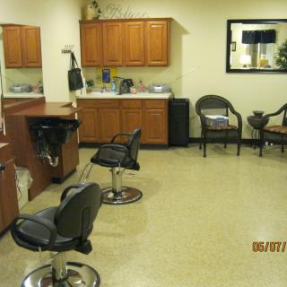 Interior of a hair salon with styling chairs and a waiting area.