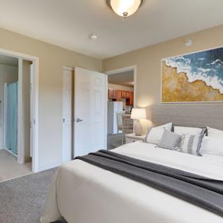 A cozy and modern bedroom featuring a comfortable bed, stylish decor, and warm lighting.