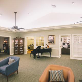 A cozy lounge area featuring a piano and comfortable seating, ideal for relaxation and social gatherings.