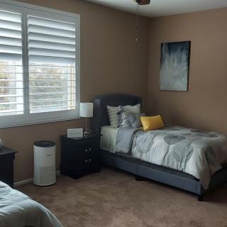 A cozy bedroom with twin beds and a nightstand by the window.