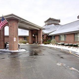 A building entrance with an American flag and snow on the ground.