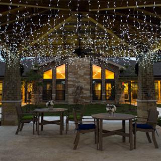 A beautifully illuminated outdoor dining area featuring twinkling lights and a welcoming ambiance.