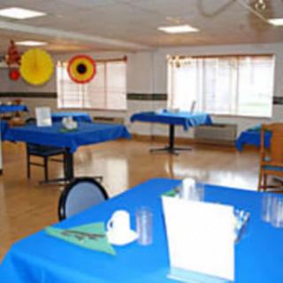 A dining hall with blue tablecloths and colorful decorations.