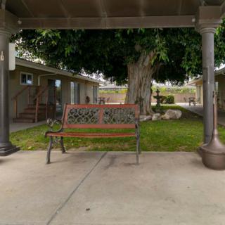 An outdoor bench on a patio with a garden view.