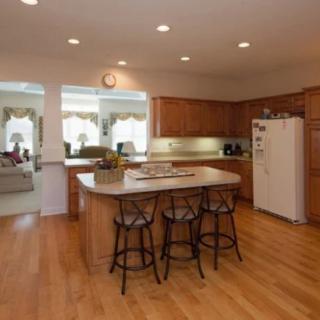 A spacious kitchen with an island and wooden cabinets.