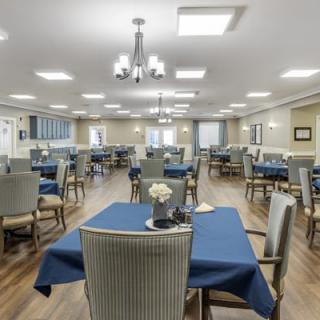 A spacious dining area with blue tablecloths and modern lighting.