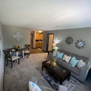 A cozy living room with a sofa, coffee table, and a small dining area.