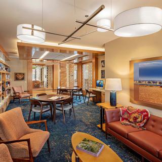 A modern library interior with comfortable seating and warm lighting.