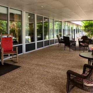 A cozy patio area with comfortable seating and large glass windows.