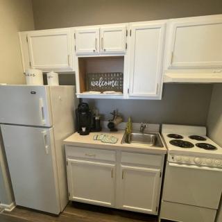 Compact kitchen setup with white cabinetry and essential appliances.
