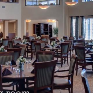 A spacious dining room with elegantly set tables and chairs, featuring a stylish interior design.