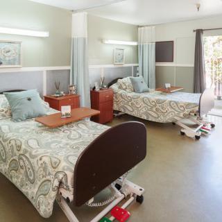 A well-organized hospital room with two beds and modern amenities.