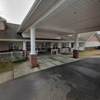 A welcoming entrance to a residential building, featuring a covered porch and accessible driveway.