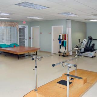 A physical therapy clinic with rehabilitation equipment and exercise stations.