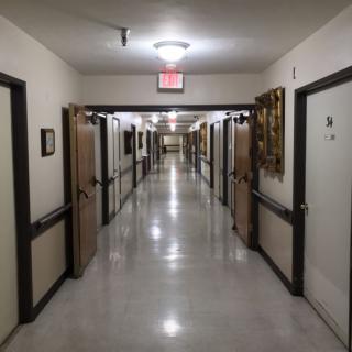 A long, well-lit hallway with multiple doors.
