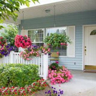 A charming front porch adorned with vibrant flowers and hanging baskets.