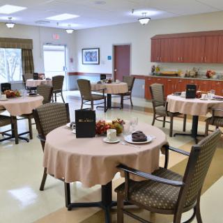 A spacious and inviting dining area featuring neatly set tables and comfortable seating.