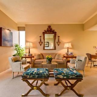 A cozy living room with elegant furnishings, featuring a sofa, mirror, and stylish decor.