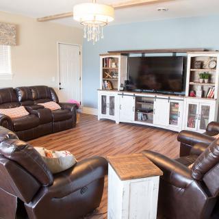 A cozy living room with leather sofas and a large entertainment center.