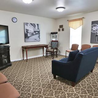 A cozy living room with comfortable seating, a television, and decorative wall art.