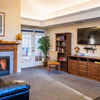 A cozy living room with a fireplace, television, and bookshelf.