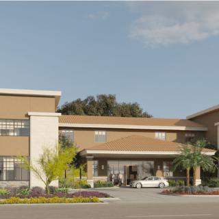 A contemporary building with a driveway and landscaped surroundings.