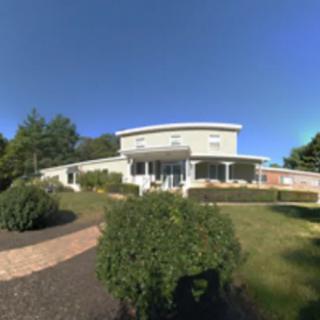 A modern house with a well-maintained garden under a clear blue sky.