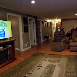 A cozy living room with a large TV and comfortable recliners.
