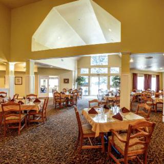 A spacious and well-lit dining area with neatly arranged tables and chairs.