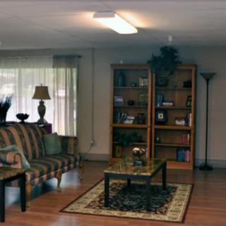 A cozy living room with a sofa, coffee table, and bookshelf.