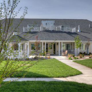 A spacious suburban house with a well-maintained lawn and inviting front porch.