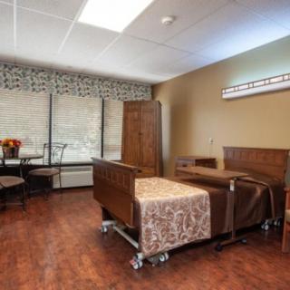 A clean and organized hospital room with a bed and simple furnishings.