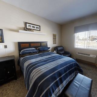 A cozy bedroom with a neatly made bed featuring striped bedding.
