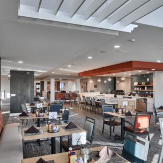 A modern restaurant interior with neatly arranged tables and chairs.