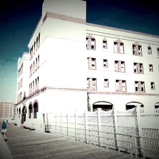 A striking view of a large building set against a clear blue sky, with a pathway and fence in the foreground.