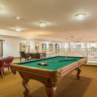 A spacious game room featuring a billiards table and seating area.