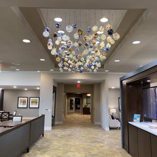 A modern lobby features a unique chandelier art installation.