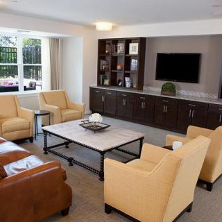 A cozy living room with comfortable seating, a TV, and bookshelves.