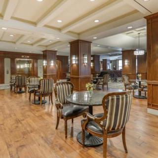Elegant dining area with wooden interiors and striped chairs.